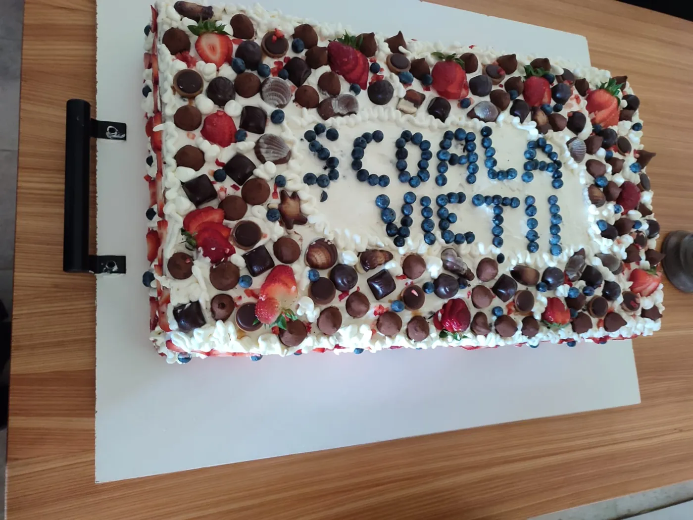 Tort decorat cu fructe de pădure, cu inscripția Școala Vieții, realizat la atelierul de cofetărie